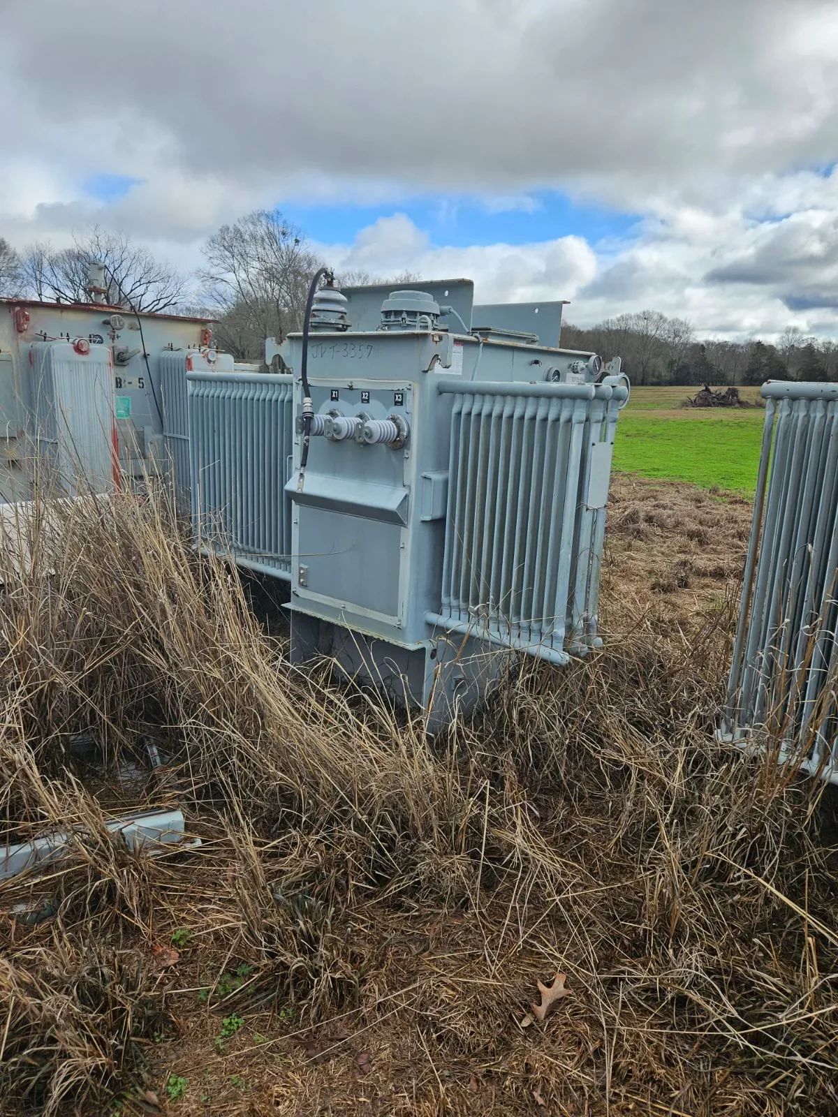Used oil-filled electrical transformer in outdoor field inventory